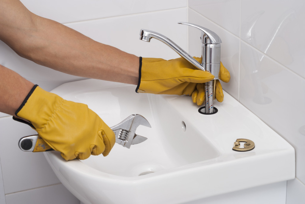 man fixing a faucets