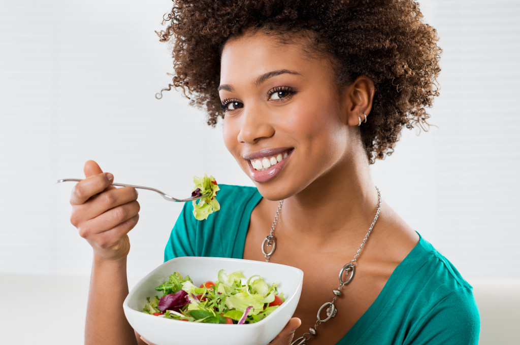 Close-up Of Beautiful African American Woman Eating Salad At Home