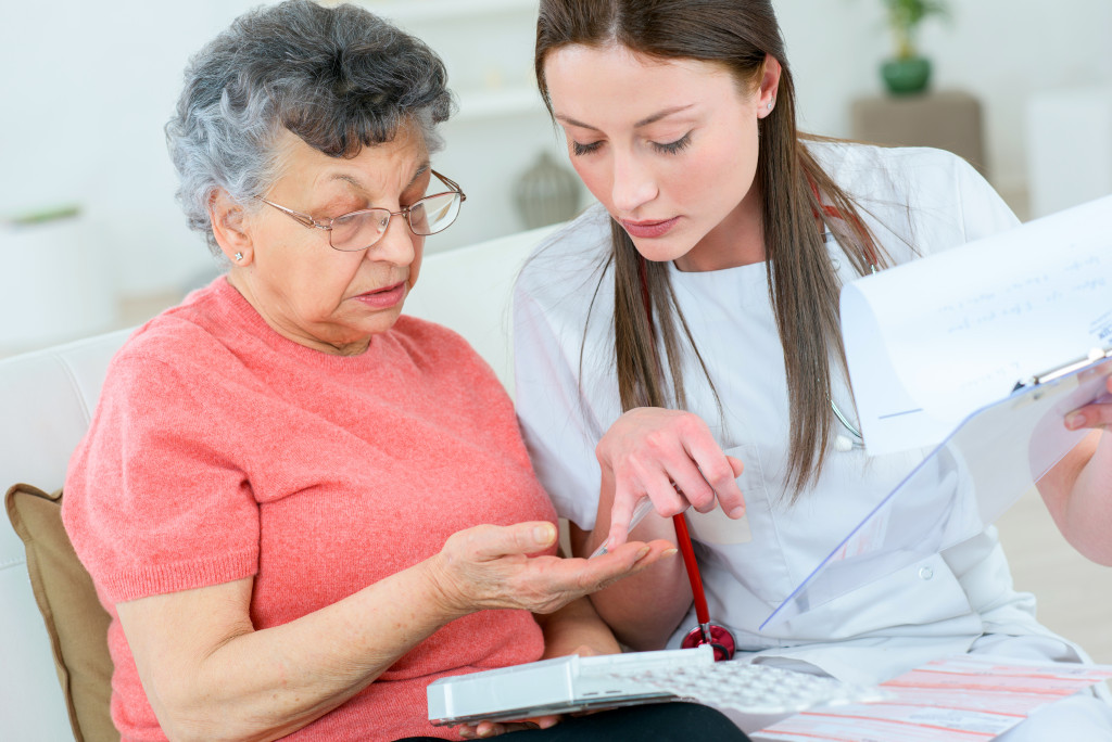 Healthcare professional helping an older woman with her medication