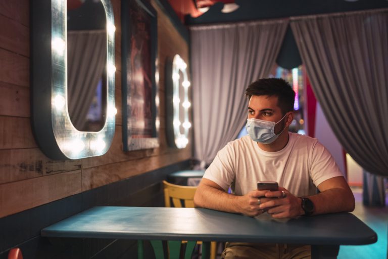 man sitting at the table with a mask