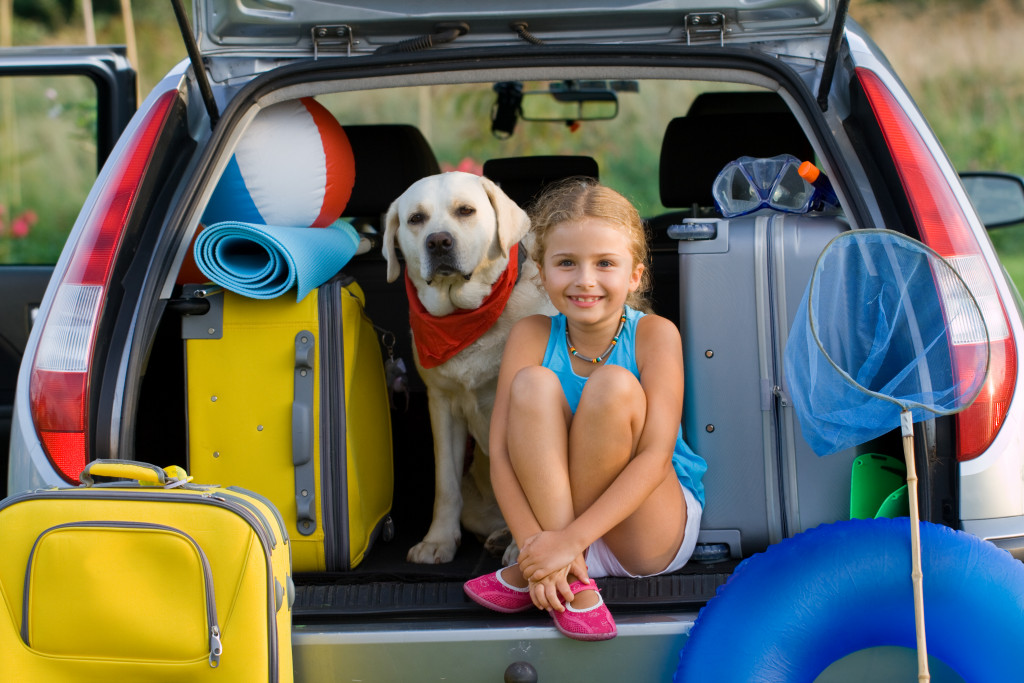child and dog in a trunk of a car