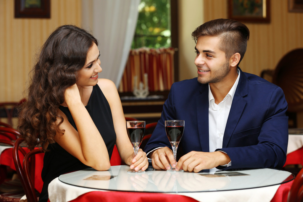 a man and woman at a restaurant having a glass of wine