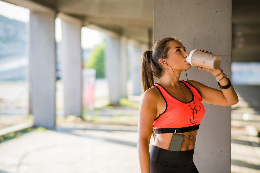 a woman drinking coffee while jogging