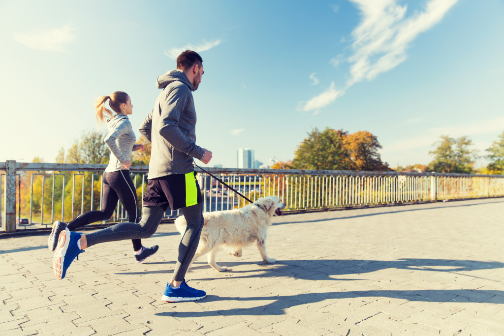 Couple out for a jog with their dog