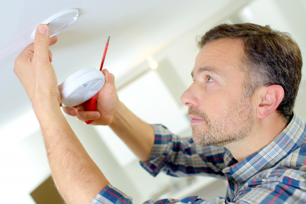 a man installing a smoke detector 