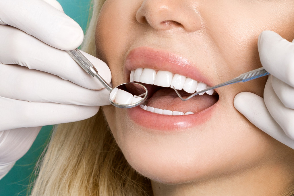 young beautiful woman with white teeth getting dental checkup