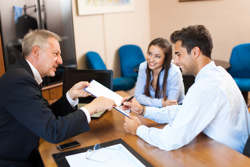 a divorce lawyer letting a man sign on a document