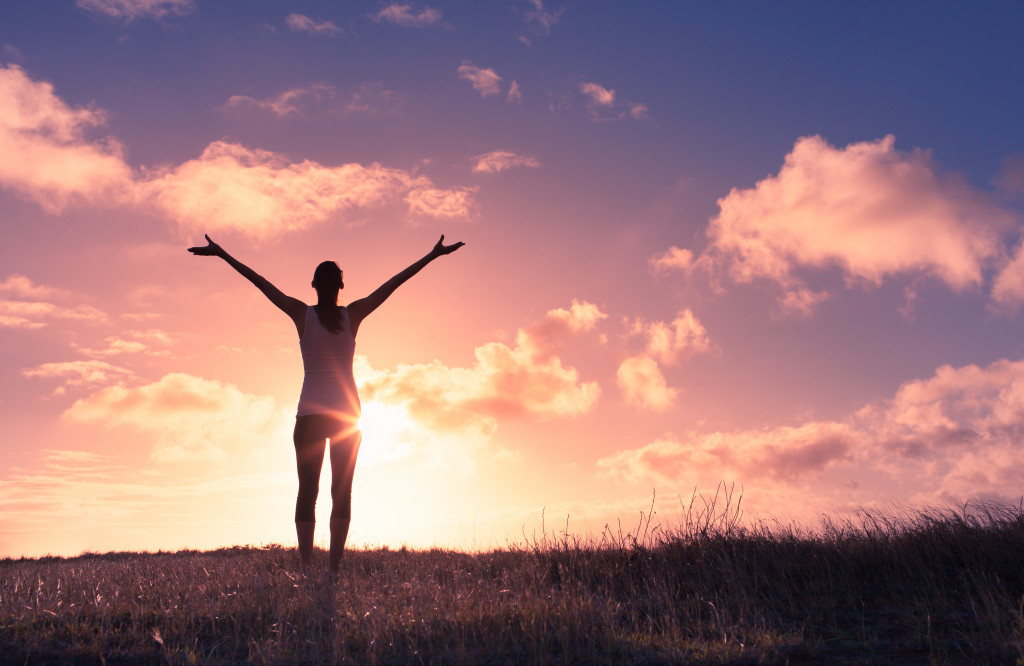 A person with its arms wide open on a sunset background