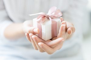 A female hand holding a small gift box