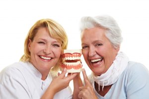 two old woman holding a denture