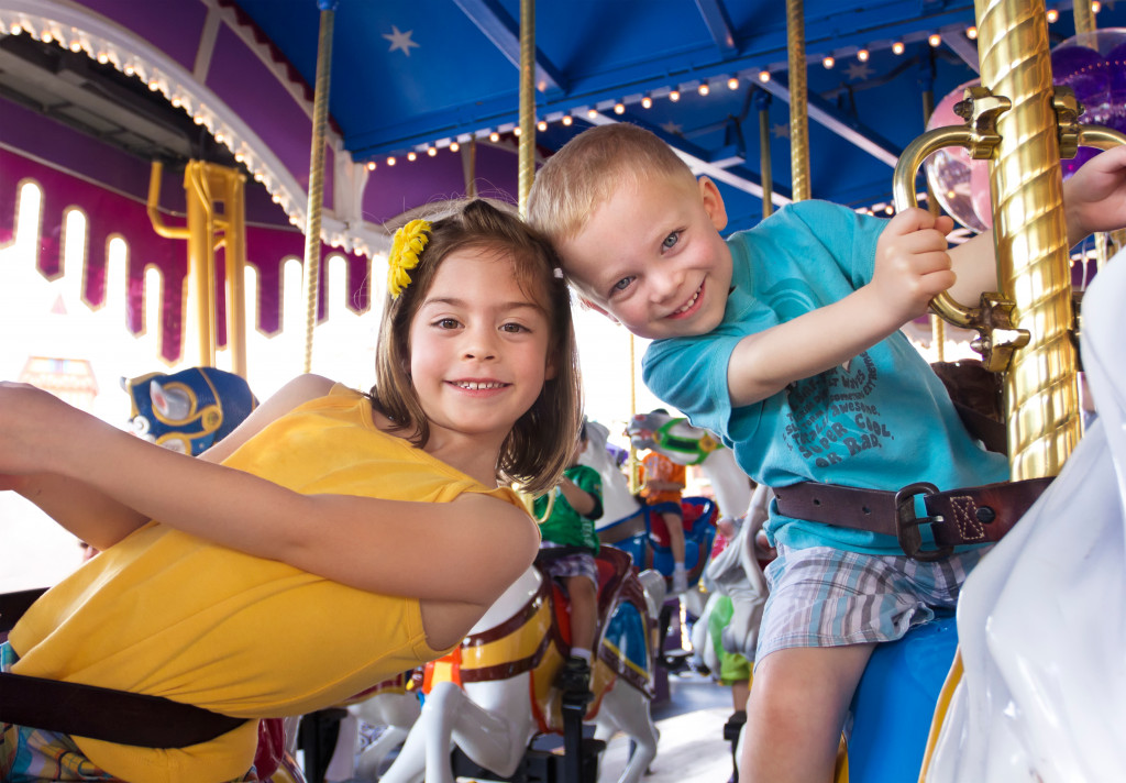 siblings enjoying a carousel ride