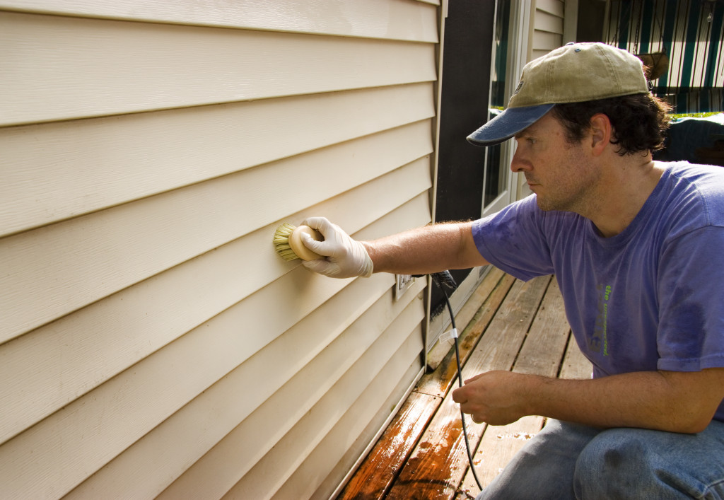 man washing vinyl siding