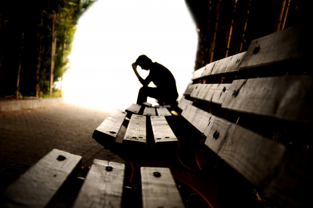 Depressed man sitting on a bench