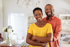 A couple at home smiling to the camera