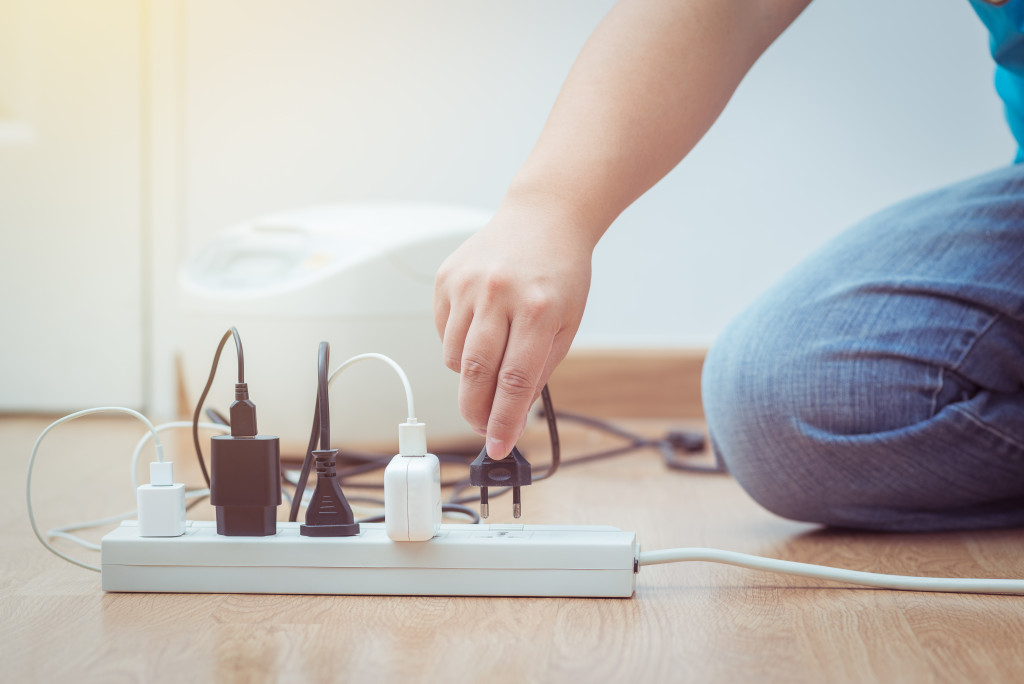 man unplugging electronics to save energy