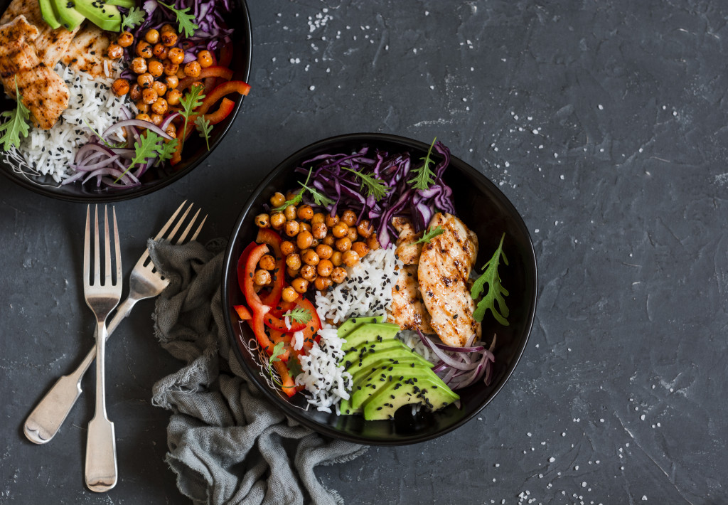 two black plates with healthy food in a black table