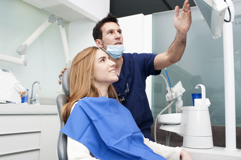 male dentist talking to female patient in the clinic