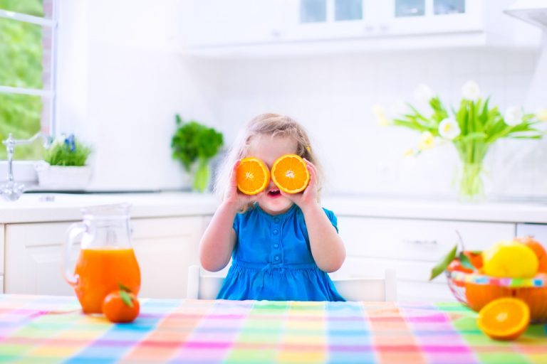 child holding oranges
