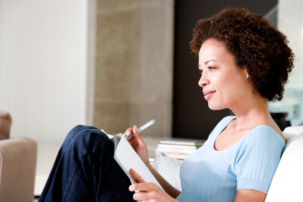 Woman writing a diary or journal, relaxing at home