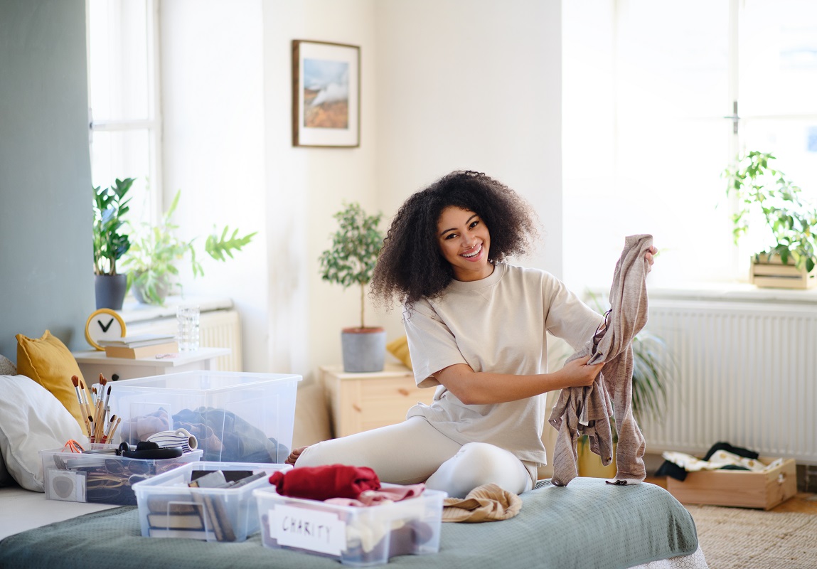 Young woman sorting clothing inside the home.