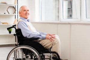 Side view elder sitting on wheelchair