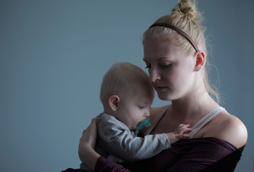 sad mom holding a baby